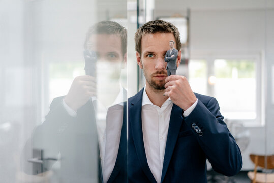 Businessman holding his 3D portrait in front of his eye