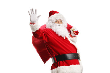 Santa claus waving and carrying a sack of presents