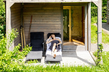 Woman relaxing on a lounge outside sauna