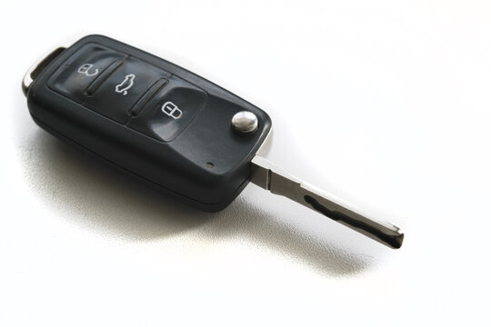 Isolated white background of black modern car key. Close up car key fob.