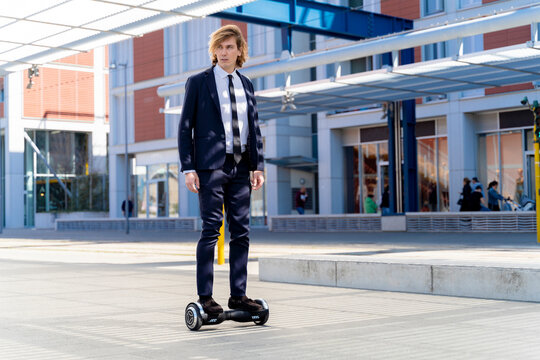 Italy, Florence, young businessman riding hoverboard in the city