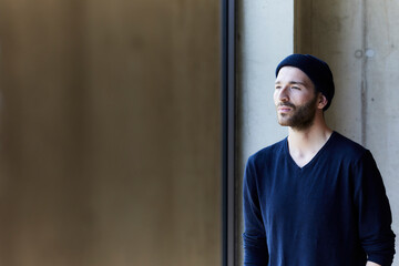 Young man wearing beanie looking out of window