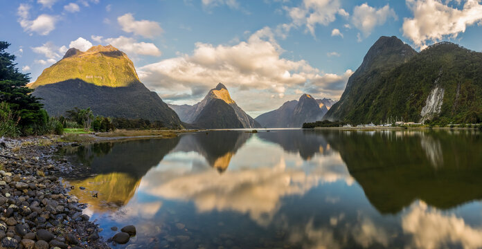 New Zealand, Scenic view of clouds and mountains reflecting on shiny surface of Milford Sound