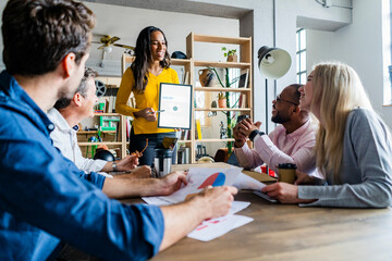 Smiling businesswoman leading a presentation in loft office