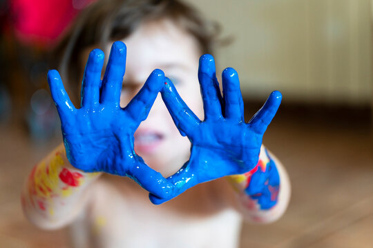 Little girl's blue painted hands, close-up