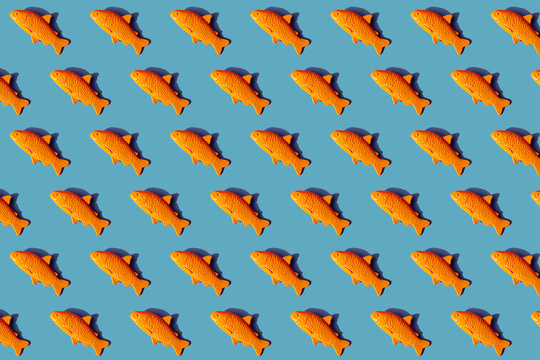 Pattern of yellow plastic fish against blue background