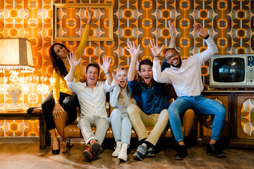 Group of happy people sitting on couch in vintage living room