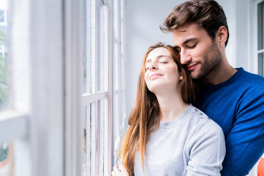 Smiling  affectionate couple at the window at home