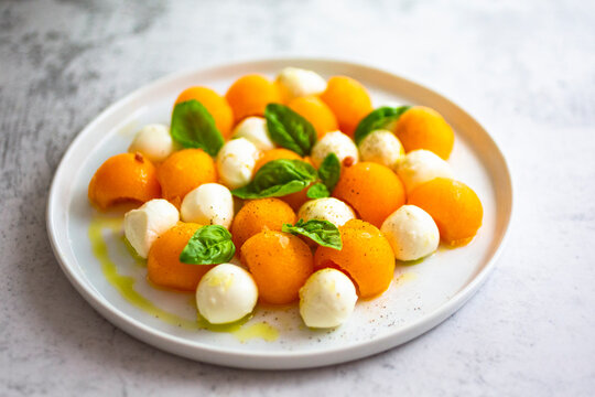 High angle view of melon served with basil and mozzarella in plate on table