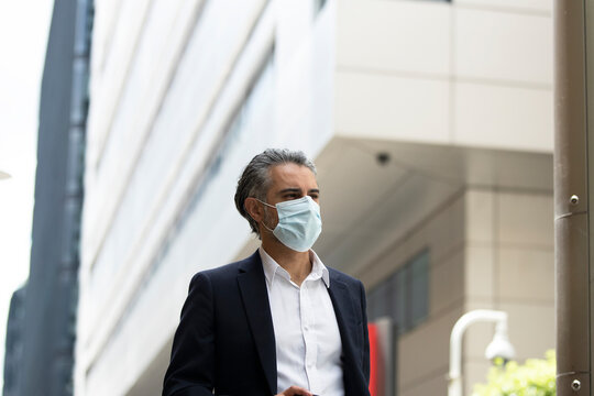 Businessman wearing protective mask in city