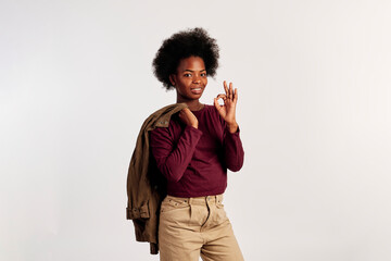 African American girl in brown sweater poses showing her hands - 462724414