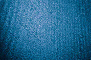 Textured background. Styrofoam in blue light. Polystyrene foam close-up. Lots of small and large bubbles. New Year color backdrop. Wallpaper with copy space. Building material. Macro. Rough surface
