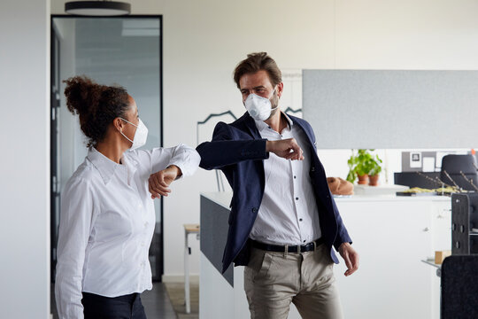Colleagues greeting each other in office during Corona crisis