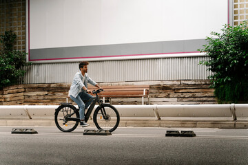 Young man riding electric bicycle on road in city
