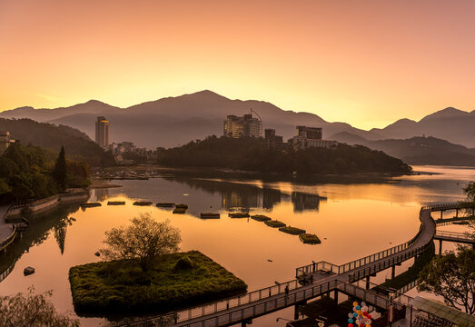 Taiwan, Nantou County, Pier stretching along shore of Sun Moon Lake at moody sunrise