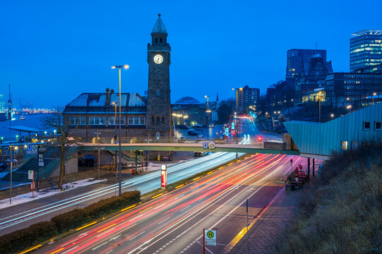 Germany, Hamburg, Vehicle light trails in front of Saint Pauli Piers clock tower at dawn