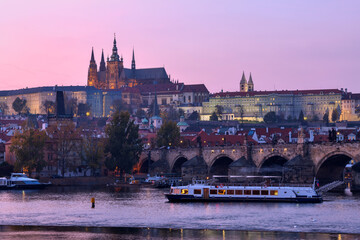 Czech Republic, Prague, Charles Bridge stretching over Vltava river at dusk with Prague Castle looming in background