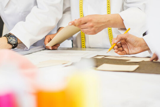 Close-up of fashion designers working on a draft
