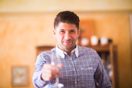 Germany, Lower Saxony, Hannover, Portrait of handsome man holding wine glass toward camera