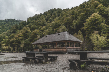 Old abandoned wooden alcove and tables in the forest mountains on a gloomy day
