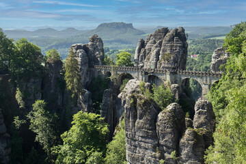 Panorama of Saxon Switzerland against a blue cloudy sky in the Elbe Sandstone Mountains from the river valley of the Elbe.