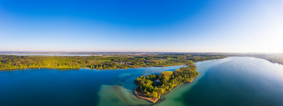 Germany, Bavaria, Inning am Ammersee, Drone panorama of clear sky over forested shore of Worth island