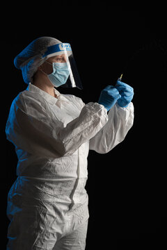 Woman in protective wear holding syringe