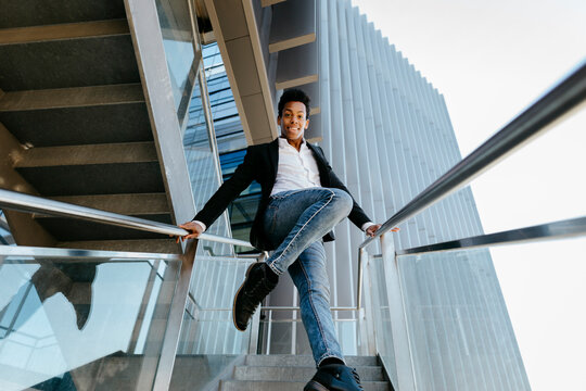 Smiling male professional dancing on staircase against building