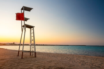 Egypt, Hurghada, Empty lifeguard chair standing on sandy coastal beach of Sahl Hasheesh bay at sunset