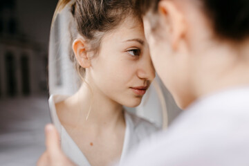 Close-up of young woman looking at mirror reflection