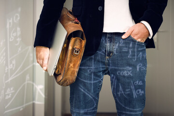 Mature male professional with hand in pocket, laptop and bag