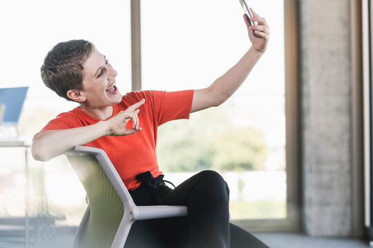 Carefree businesswoman using smartphone in office
