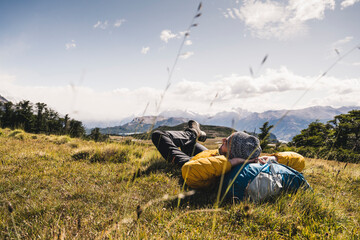Man with hands behind head resting on mountain at Patagonia, Argentina, South America