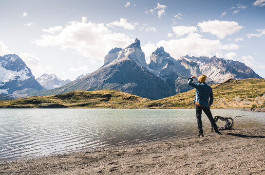 Hiker in mountainscape at lakeside in Torres del Paine National Park, Patagonia, Chile
