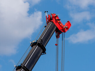 Telescopic boom of a mobile crane against a cloudy sky, close-up. Construction and repair equipment...