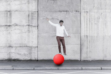 Man balancing on fitness ball against wall