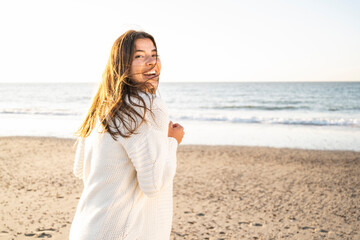 Cheerful beautiful woman spending leisure time at beach during sunny day