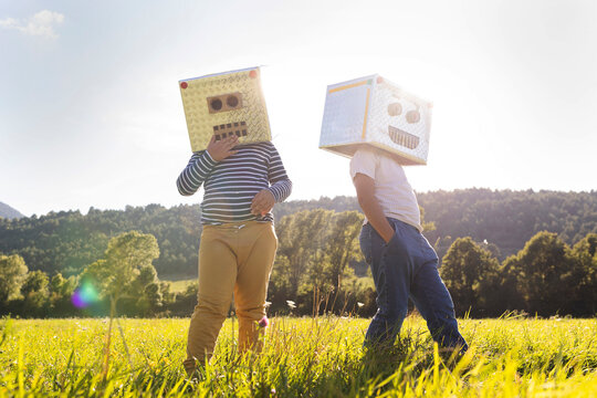 Boy playing while covering face with robot cardboard box