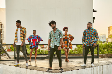 Friends in colorful clothes standing on roof terrace in the city, Maputo, Mozambique