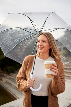 Smiling woman with bamboo cup against retaining wall during rainy season