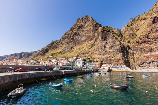 Portugal, Madeira Island, Paul do Mar, Fishing boats moored in harbor, mountain and town in background