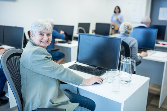 Confident senior woman attending computer course