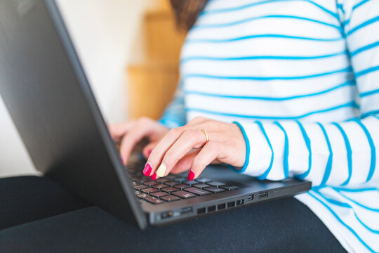 Woman using laptop, typing on keyboard