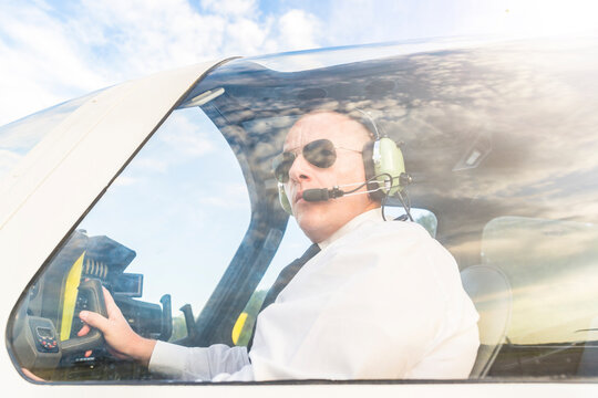 Pilot with headset, sitting in sports plane