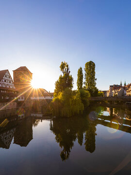 Germany, Bavaria, Nuremberg, Henkersteg,&Ocirc;&oslash;&Omega;Weinstadel&Ocirc;&oslash;&Omega;and&Ocirc;&oslash;&Omega;Wasserturm&Ocirc;&oslash;&Omega;reflecting in river&Ocirc;&oslash;&Omega;Pegnitz&Ocirc;&oslash;&Omega;at sunset