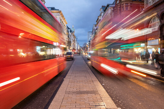 UK, London, Red double decker buses on Oxford street at dusk, blurred