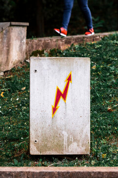 Georgia, Imereti, Kutaisi, High voltage sign on box, mans legs in background