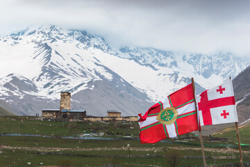 Georgia, Svaneti, Ushguli, Georgian flags fluttering in front of medieval village