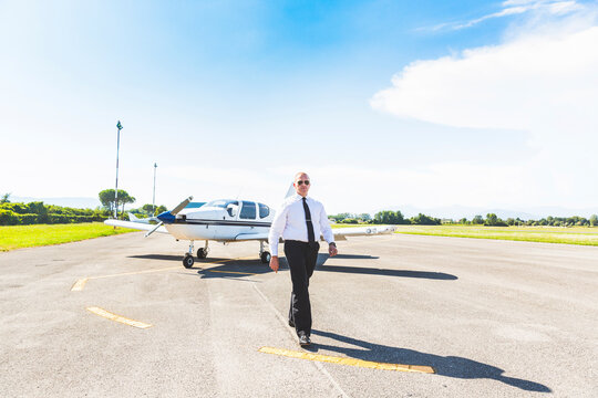 Poilot Walking On Runway, Sports Plane In Background