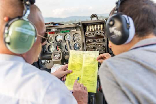 Plot and copilot sitting in sports plane, going through check list